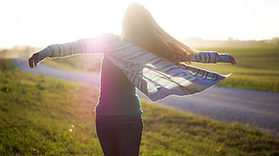 woman wearing striped jacket standing on grass field